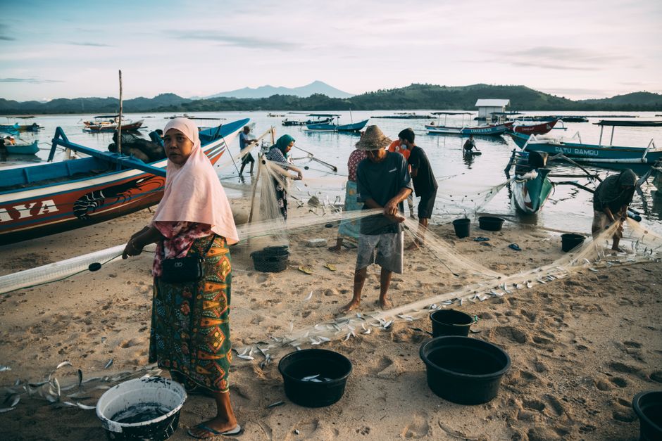 Nelayan Indonesia menarik jaring di pantai